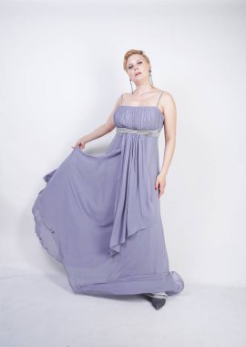 gri uzun elbise zarif kalın kadın. beyaz stüdyo arka plan üzerinde duran gece elbisesi güzel artı boyutu kadın. gri giysiler içinde kısa saç tombul kız tek başına poz.