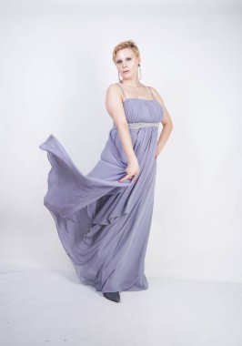 gri uzun elbise zarif kalın kadın. beyaz stüdyo arka plan üzerinde duran gece elbisesi güzel artı boyutu kadın. gri giysiler içinde kısa saç tombul kız tek başına poz.