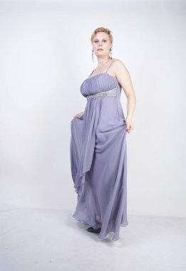 gri uzun elbise zarif kalın kadın. beyaz stüdyo arka plan üzerinde duran gece elbisesi güzel artı boyutu kadın. gri giysiler içinde kısa saç tombul kız tek başına poz.