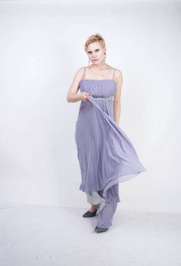 gri uzun elbise zarif kalın kadın. beyaz stüdyo arka plan üzerinde duran gece elbisesi güzel artı boyutu kadın. gri giysiler içinde kısa saç tombul kız tek başına poz.