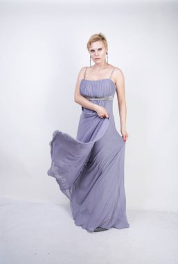 gri uzun elbise zarif kalın kadın. beyaz stüdyo arka plan üzerinde duran gece elbisesi güzel artı boyutu kadın. gri giysiler içinde kısa saç tombul kız tek başına poz.