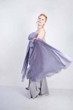 gri uzun elbise zarif kalın kadın. beyaz stüdyo arka plan üzerinde duran gece elbisesi güzel artı boyutu kadın. gri giysiler içinde kısa saç tombul kız tek başına poz.