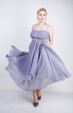 gri uzun elbise zarif kalın kadın. beyaz stüdyo arka plan üzerinde duran gece elbisesi güzel artı boyutu kadın. gri giysiler içinde kısa saç tombul kız tek başına poz.