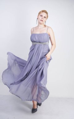 gri uzun elbise zarif kalın kadın. beyaz stüdyo arka plan üzerinde duran gece elbisesi güzel artı boyutu kadın. gri giysiler içinde kısa saç tombul kız tek başına poz.