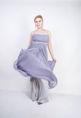 gri uzun elbise zarif kalın kadın. beyaz stüdyo arka plan üzerinde duran gece elbisesi güzel artı boyutu kadın. gri giysiler içinde kısa saç tombul kız tek başına poz.