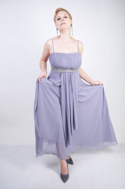 gri uzun elbise zarif kalın kadın. beyaz stüdyo arka plan üzerinde duran gece elbisesi güzel artı boyutu kadın. gri giysiler içinde kısa saç tombul kız tek başına poz.