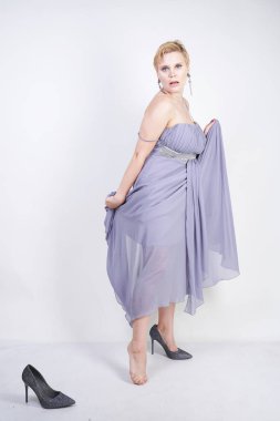 gri uzun elbise zarif kalın kadın. beyaz stüdyo arka plan üzerinde duran gece elbisesi güzel artı boyutu kadın. gri giysiler içinde kısa saç tombul kız tek başına poz.