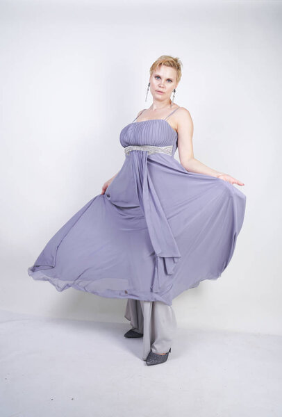 элегантная толстая женщина в сером длинном платье. симпатичная женщина plus size в вечернем платье, стоящая на белом студийном фоне. короткие волосы пухлая девушка в серой одежде позирует в одиночку
.