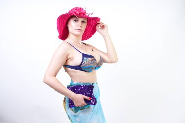 kıvrımlı rakam ile sevimli kız Studio beyaz arka plan üzerinde pareo ile fuşya pembe şapka ve mavi mayo duruyor. tek başına poz moda beachwear güzel kıvrımlı tombul kadın.