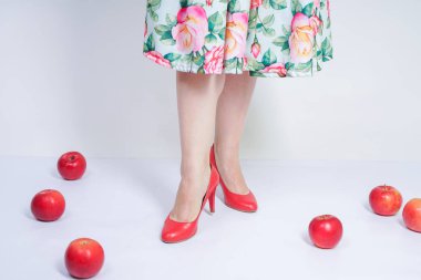 kırmızı elma ile poz mutlu kafkas genç kız kadar güzel pin. tek başına beyaz arka plan meyve ile eğlenmek retro elbise sevimli vintage bayan. vejetaryen komik kadın iyi gıda ve vitamin seviyor