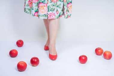 kırmızı elma ile poz mutlu kafkas genç kız kadar güzel pin. tek başına beyaz arka plan meyve ile eğlenmek retro elbise sevimli vintage bayan. vejetaryen komik kadın iyi gıda ve vitamin seviyor