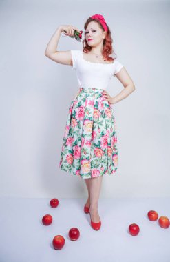 kırmızı elma ile poz mutlu kafkas genç kız kadar güzel pin. tek başına beyaz arka plan meyve ile eğlenmek retro elbise sevimli vintage bayan. vejetaryen komik kadın iyi gıda ve vitamin seviyor