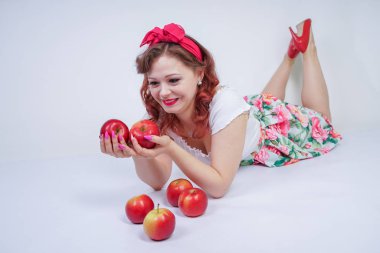 kırmızı elma ile poz mutlu kafkas genç kız kadar güzel pin. tek başına beyaz arka plan meyve ile eğlenmek retro elbise sevimli vintage bayan. vejetaryen komik kadın iyi gıda ve vitamin seviyor