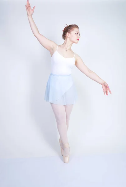 バレエ服を着たかわいい白人の女の子は スタジオで白い背景にバレリーナであることを学びます プラスサイズの若い女性はダンサーになることを夢見る — ストック写真