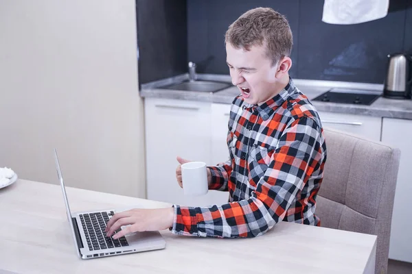 Уставший Молодой Человек Клетчатой Рубашке Сидит Столом Перед Ноутбуком Один — стоковое фото