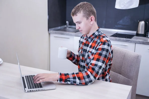 Schattige Jonge Kerel Zittend Een Geruite Overhemd Met Een Laptop — Stockfoto