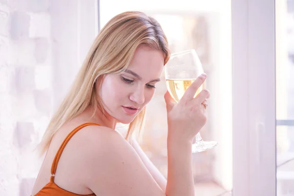 漂亮加大小白种妇女喝葡萄酒在早上独自在家里的白色毛皮窗台 — 图库照片