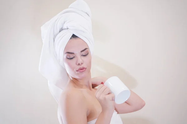 Young girl sitting in the kitchen after a shower wrapped in a white towel and resting — Stockfoto