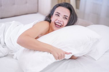 Onu beyaz yatakta dinlenmek büyüleyici genç esmer kız