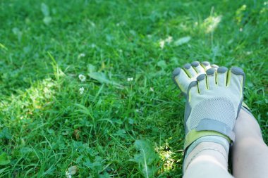 Beş parmağla sıradışı spor ayakkabıları. yaz mevsiminde garip ayakkabılar çim üzerinde yeşil park.