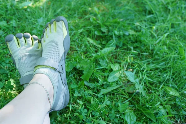 unusual sneakers with five fingers. strange shoes in summer in green Park on the grass.