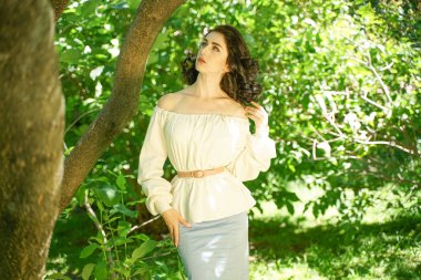 beyaz elbise güzel genç esmer kız şehir parkında ağacın gölgesinde sıcak güneşten gizlemek