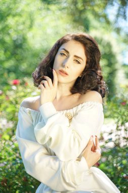 Şehir parkında güneşin tadını Olgun kadın closeup yüz. Yeşil çim ve ağaçlar yakın rahatlatıcı güzel Bayan.