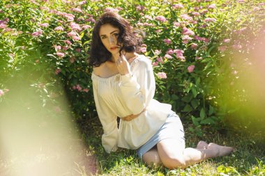 Şehir parkında güneşin tadını Olgun kadın closeup yüz. Yeşil çim ve ağaçlar yakın rahatlatıcı güzel Bayan.