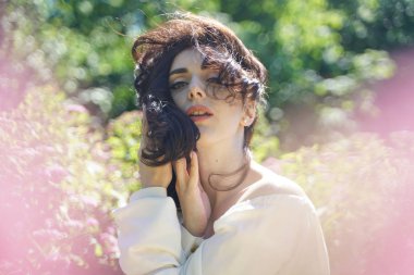 Şehir parkında güneşin tadını Olgun kadın closeup yüz. Yeşil çim ve ağaçlar yakın rahatlatıcı güzel Bayan.