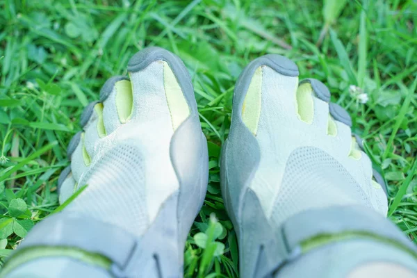 unusual sneakers with five fingers. strange shoes in summer in green Park on the grass.