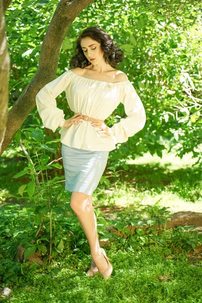 beyaz elbise güzel genç esmer kız şehir parkında ağacın gölgesinde sıcak güneşten gizlemek