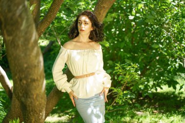 beyaz elbise güzel genç esmer kız şehir parkında ağacın gölgesinde sıcak güneşten gizlemek