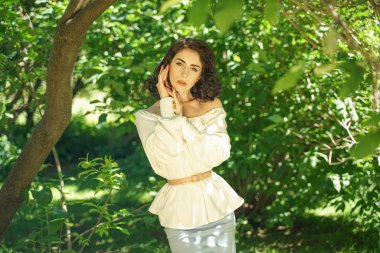 beyaz elbise güzel genç esmer kız şehir parkında ağacın gölgesinde sıcak güneşten gizlemek