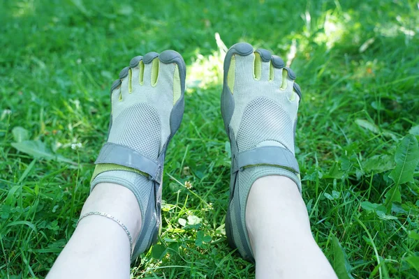 Tênis incomuns com cinco dedos. sapatos estranhos no verão no parque verde na grama . — Fotografia de Stock