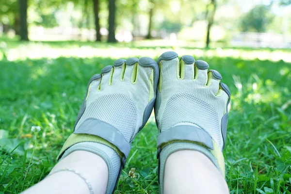 Tênis incomuns com cinco dedos. sapatos estranhos no verão no parque verde na grama . — Fotografia de Stock
