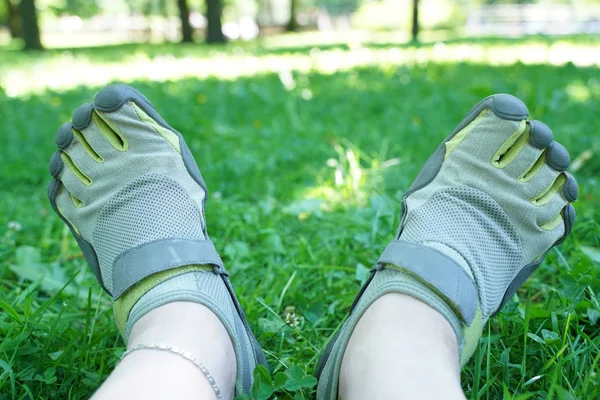 Tênis incomuns com cinco dedos. sapatos estranhos no verão no parque verde na grama . — Fotografia de Stock