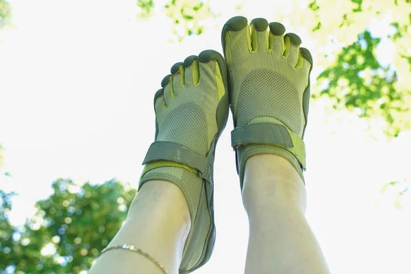 Ungewöhnliche Turnschuhe mit fünf Fingern. Seltsame Schuhe im Sommer im grünen Park auf dem Rasen. — Stockfoto