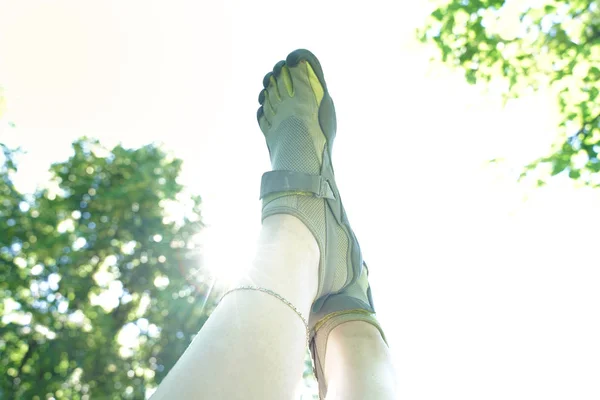 Ungewöhnliche Turnschuhe mit fünf Fingern. Seltsame Schuhe im Sommer im grünen Park auf dem Rasen. — Stockfoto