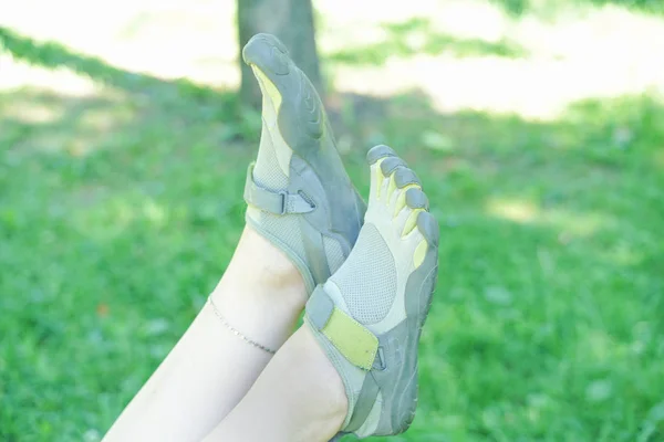Tênis incomuns com cinco dedos. sapatos estranhos no verão no parque verde na grama . — Fotografia de Stock
