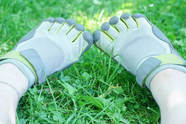 Tênis incomuns com cinco dedos. sapatos estranhos no verão no parque verde na grama . — Fotografia de Stock