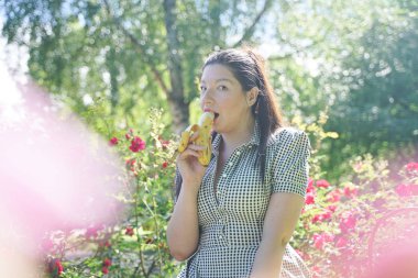 güzel artı boyutu Asya kız yemek muz şehir yaz parkta yalnız