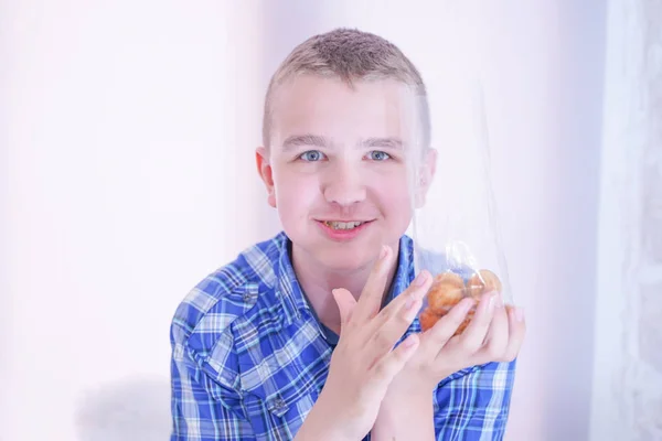 Niedliche hungrige Teenager Junge mit frischen kleinen backen Süßigkeiten auf weißem Raum Hintergrund allein — Stockfoto