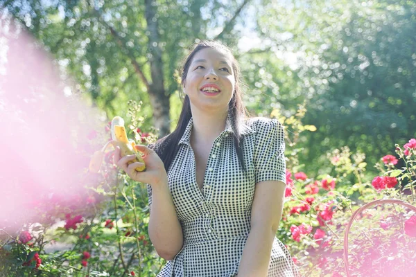 Asiática chica descansando en el verano en el parque en el intenso calor en el sol brillante solo — Foto de Stock