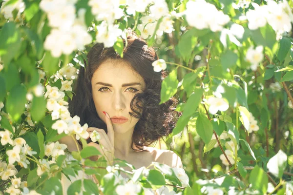 Dívka stojí mezi Jasmími křovinami a vdechuje vůni květin — Stock fotografie