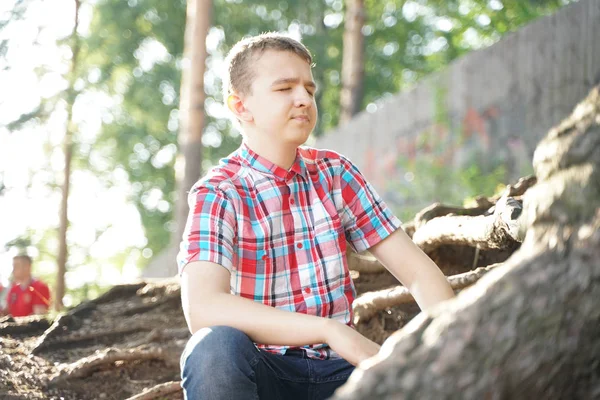 Retrato de un estudiante cansado de la escuela. el chico quiere dormir en la naturaleza . — Foto de Stock