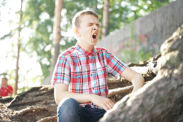 Portret van een vermoeid school student. de jongen wil slapen in de natuur. — Stockfoto