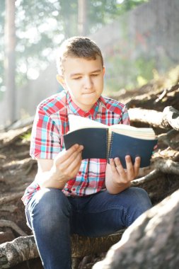 Doğa üzerinde egzersiz kitabı okuma genç çocuk