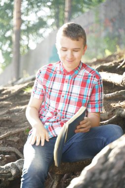 Doğa üzerinde egzersiz kitabı okuma genç çocuk