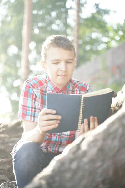 Tiener jongen lezing oefening boek over de natuur — Stockfoto