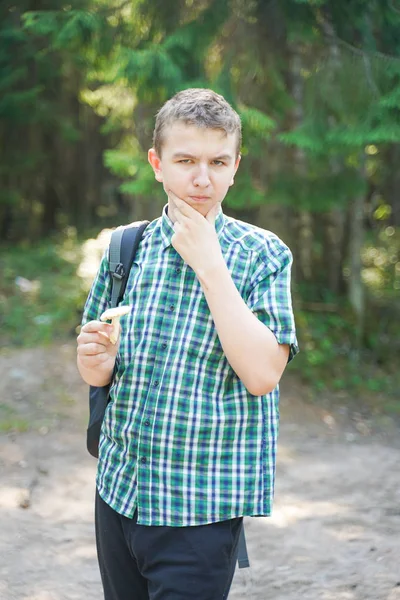 Chłopiec nastolatek z grzybami w lesie w letni dzień — Zdjęcie stockowe